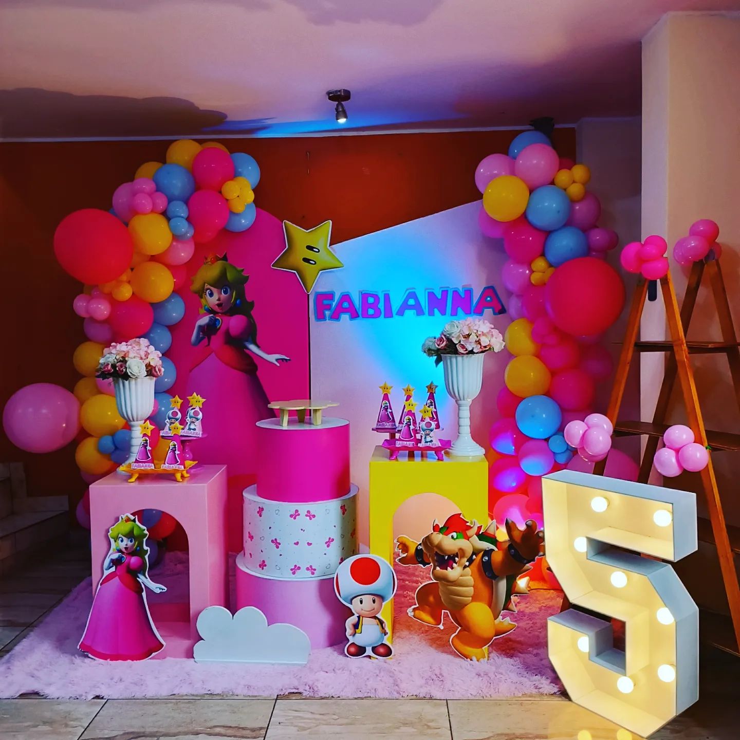 Decoración temática Mario Bros con número 5 luminoso para el cumpleaños de Fabianna