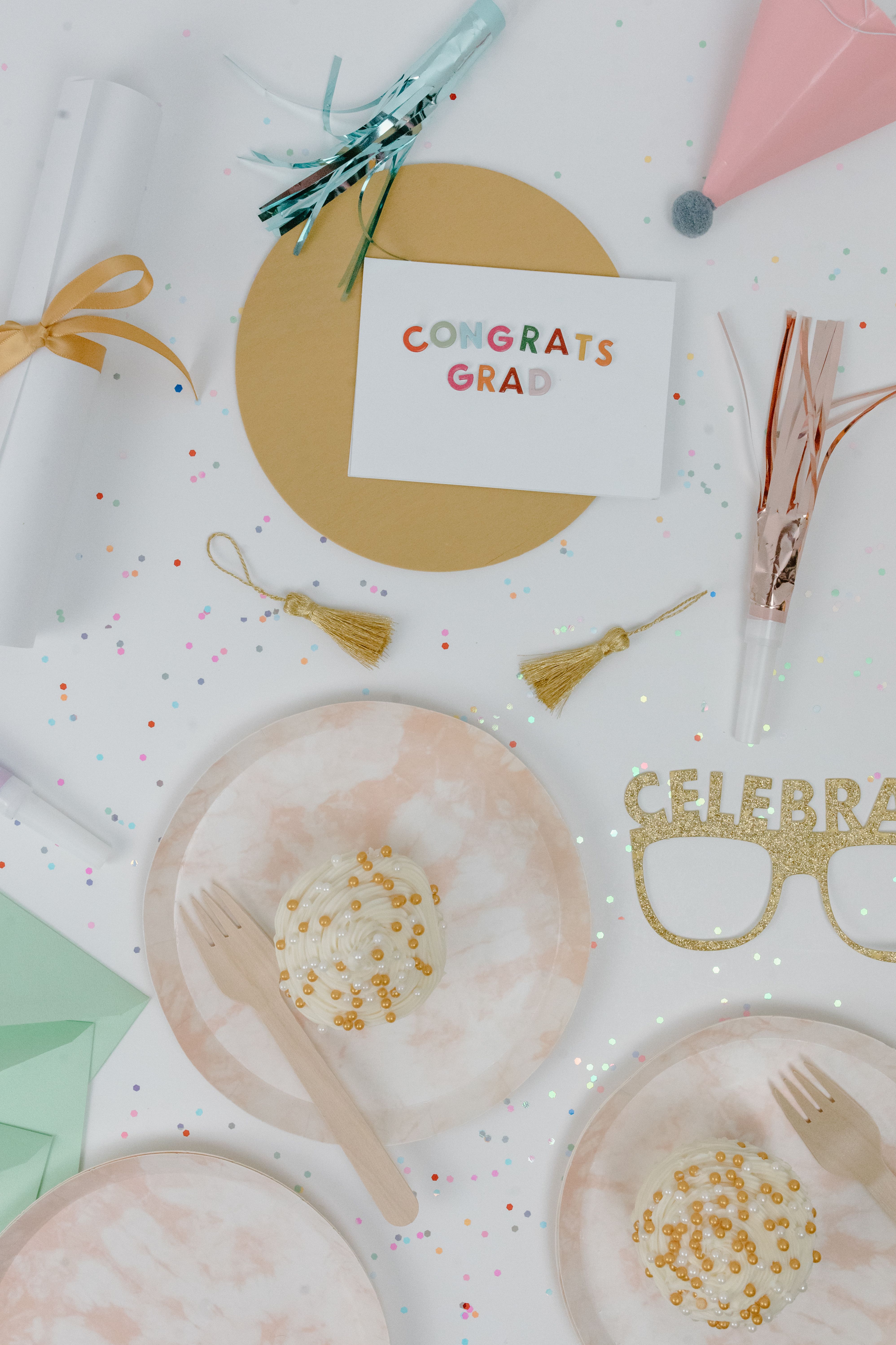 Foto referencial de estilo graduación: confeti y tarjeta de felicitación